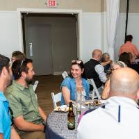 Group of 6 sitting around table all in conversation with each other